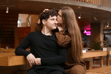 Photo of International dating. Lovely young couple spending time together in cafe