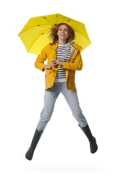 Photo of Woman with yellow umbrella jumping on white background