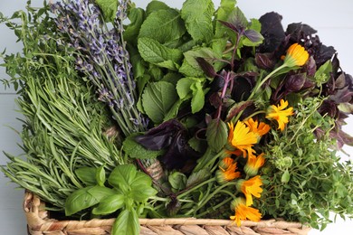 Photo of Different aromatic herbs in basket on white background, closeup