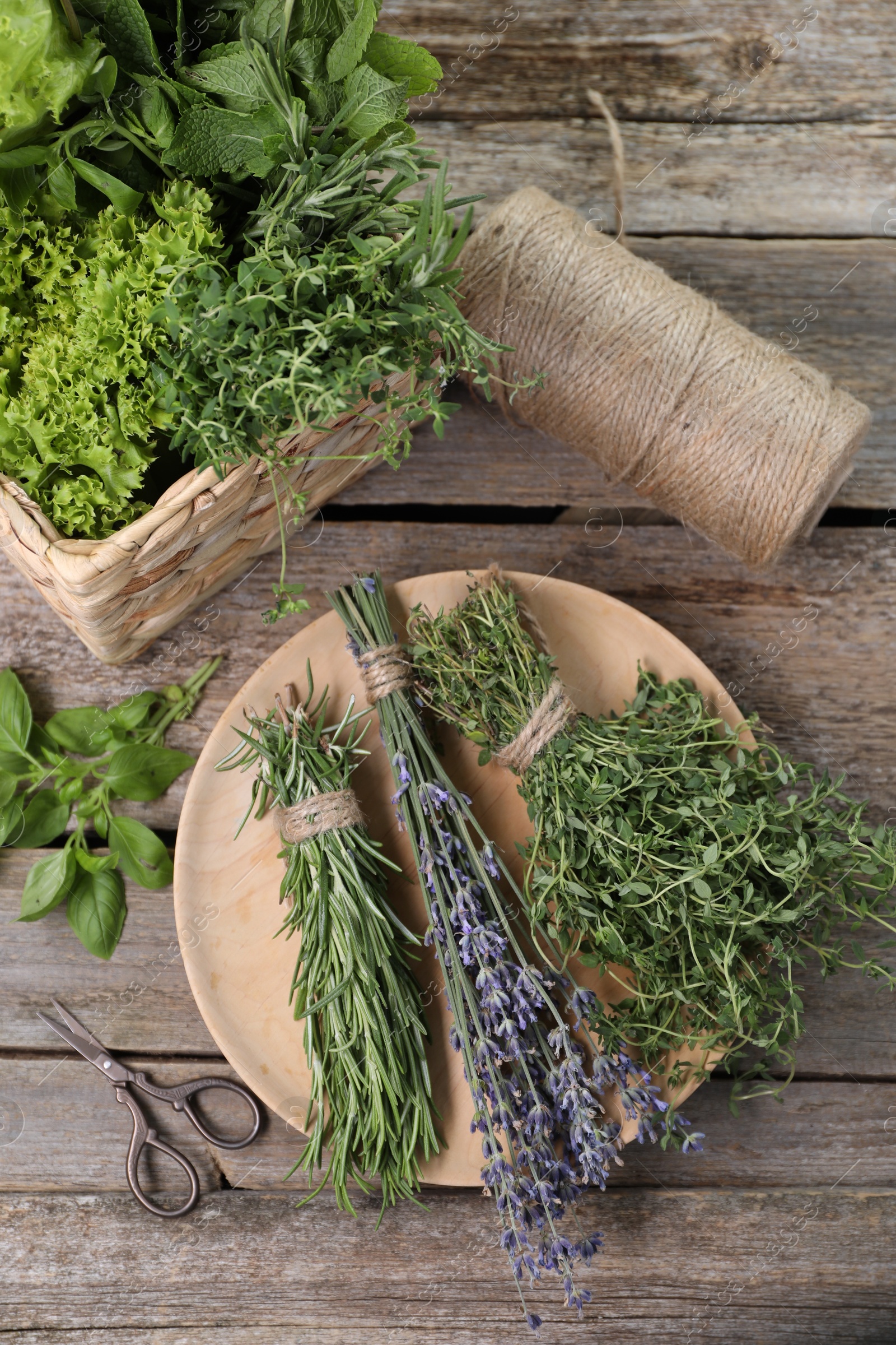 Photo of Different aromatic herbs and scissors on wooden table, flat lay