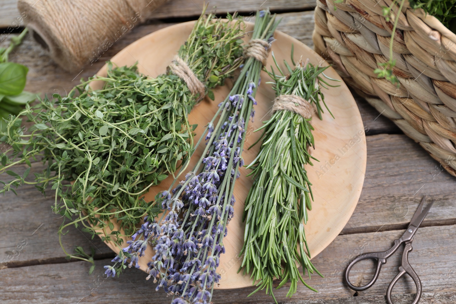 Photo of Different aromatic herbs and scissors on wooden table