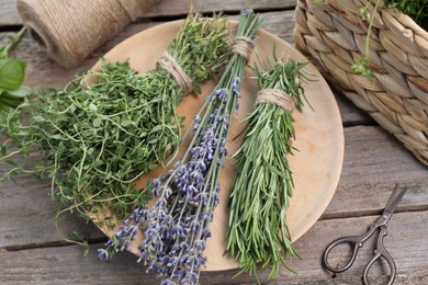 Different aromatic herbs and scissors on wooden table