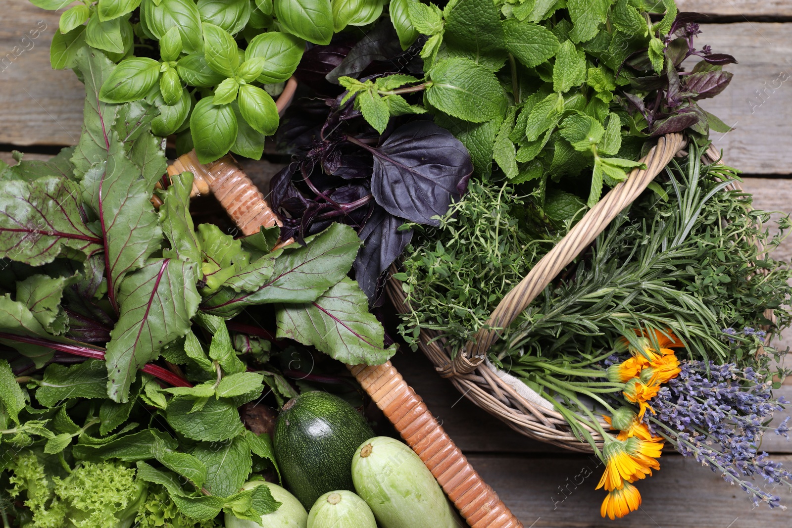 Photo of Different aromatic herbs and vegetables on wooden table, top view