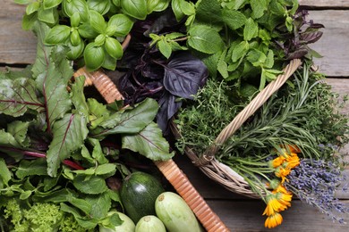 Photo of Different aromatic herbs and vegetables on wooden table, top view