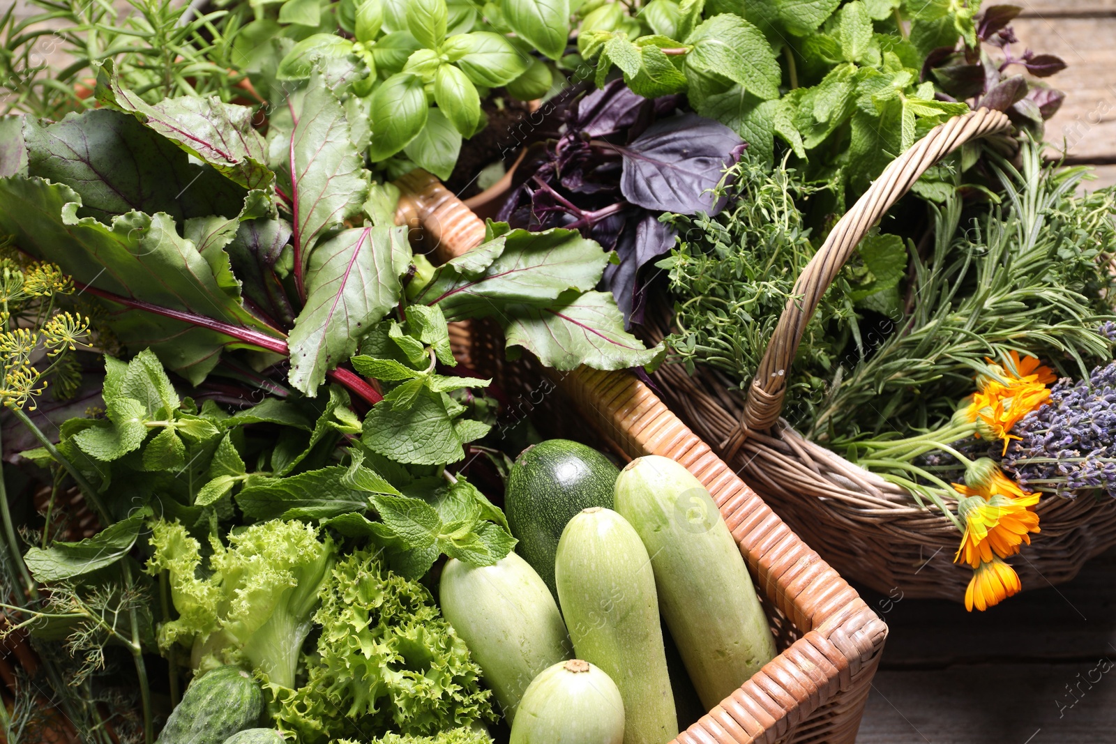 Photo of Different aromatic herbs and vegetables on wooden table