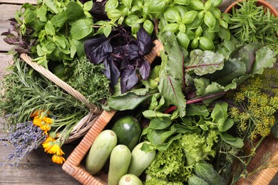 Photo of Different aromatic herbs and vegetables on wooden table, top view