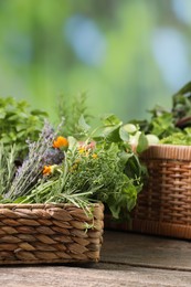 Different aromatic herbs on wooden table against blurred background, closeup