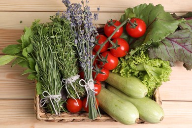 Photo of Different aromatic herbs and vegetables on wooden table, top view