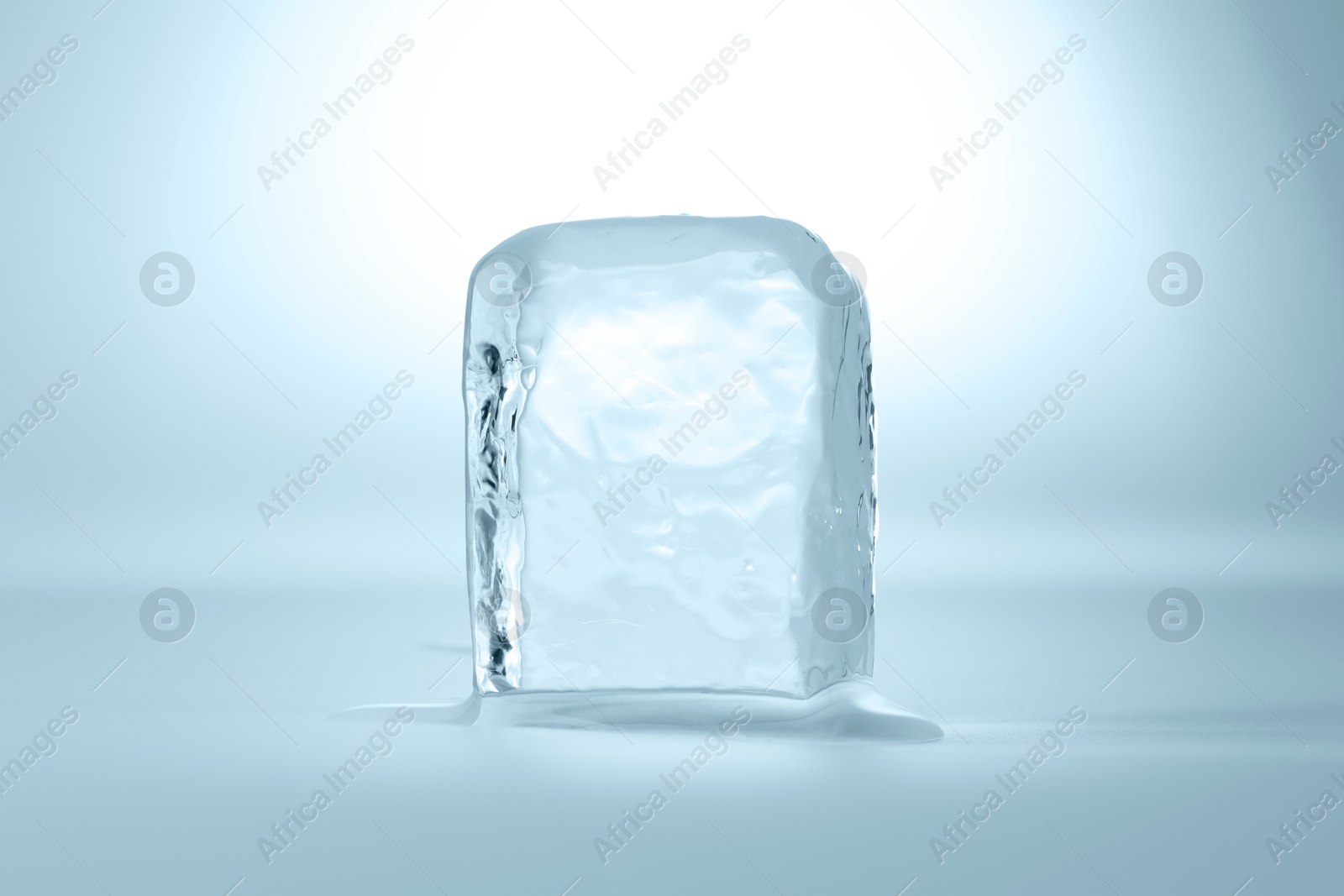 Photo of Cube of clear ice on light blue background