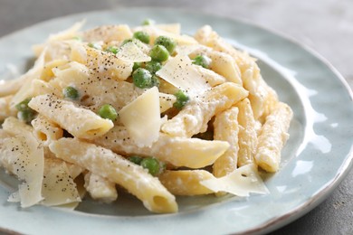 Photo of Delicious pasta with green peas, cheese and creamy sauce on table, closeup