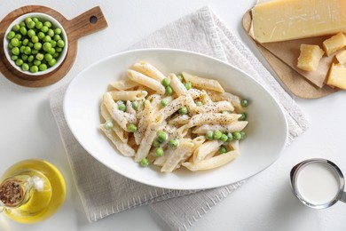 Photo of Delicious pasta with green peas and other ingredients on white table, top view