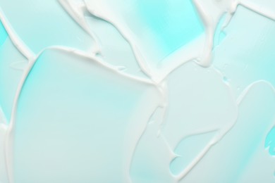 Photo of Texture of face cream on light blue background, top view