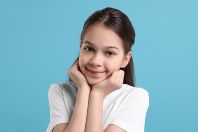 Portrait of beautiful girl on light blue background