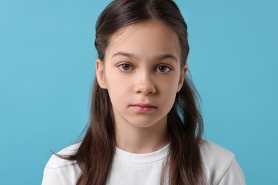 Photo of Portrait of beautiful girl on light blue background