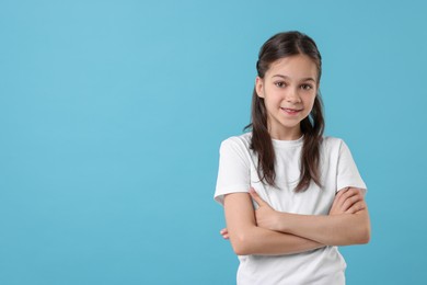 Portrait of beautiful girl on light blue background, space for text