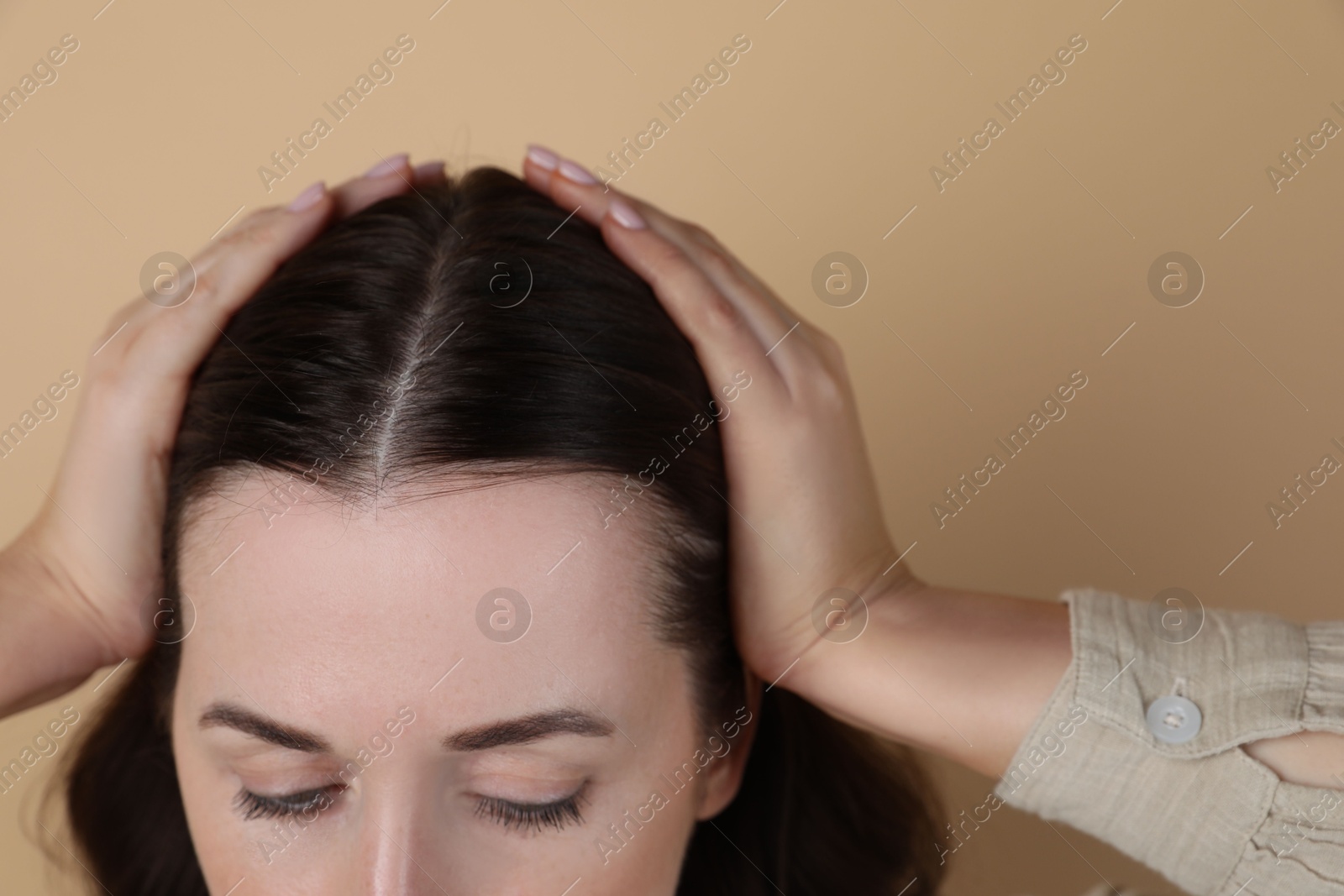 Photo of Woman with hair loss problem on beige background, closeup