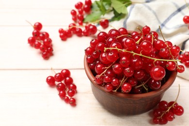 Photo of Fresh red currant berries in bowl on white wooden table, closeup