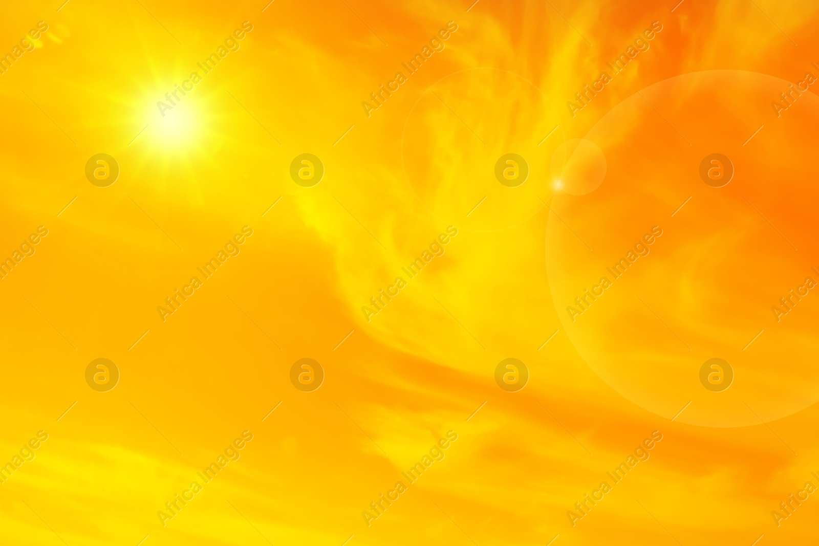 Image of Orange sky with sun and clouds during hot summer weather