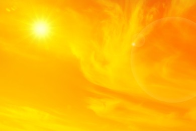 Image of Orange sky with sun and clouds during hot summer weather