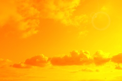 Image of Orange sky with clouds during hot summer weather