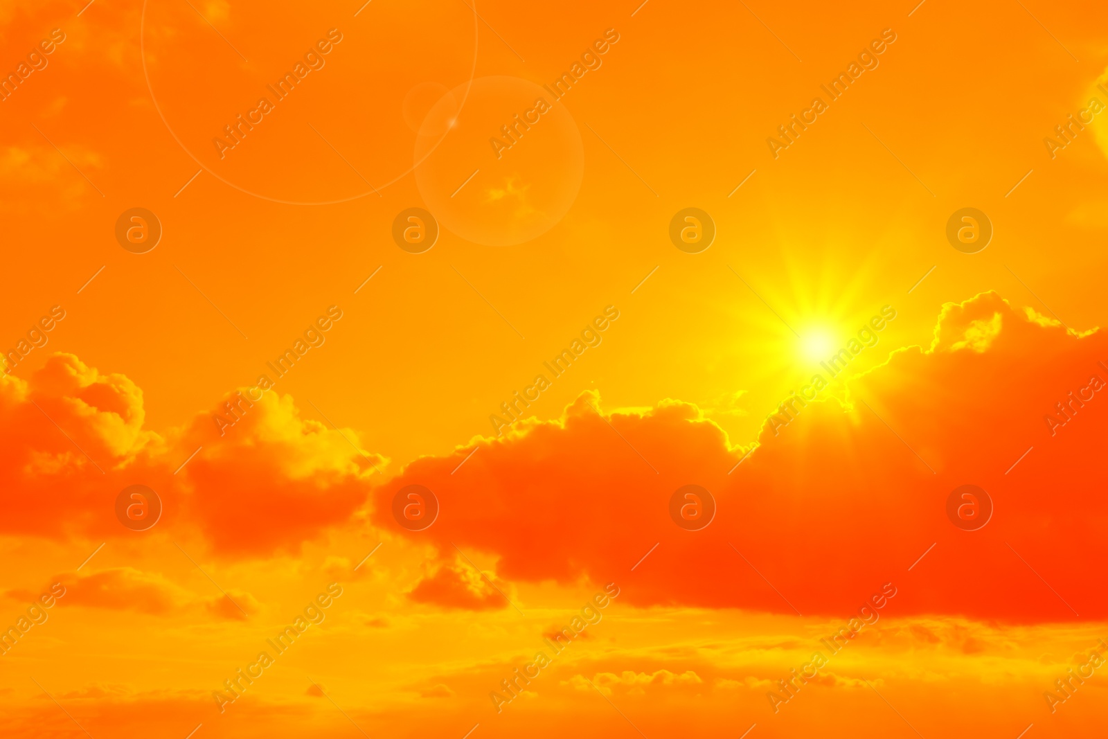 Image of Orange sky with sun and clouds during hot summer weather