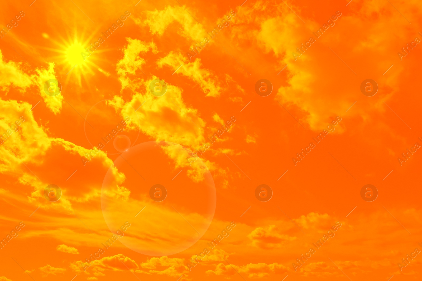 Image of Orange sky with sun and clouds during hot summer weather