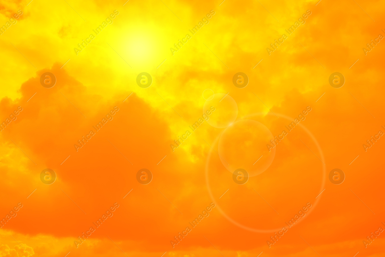 Image of Orange sky with sun and clouds during hot summer weather