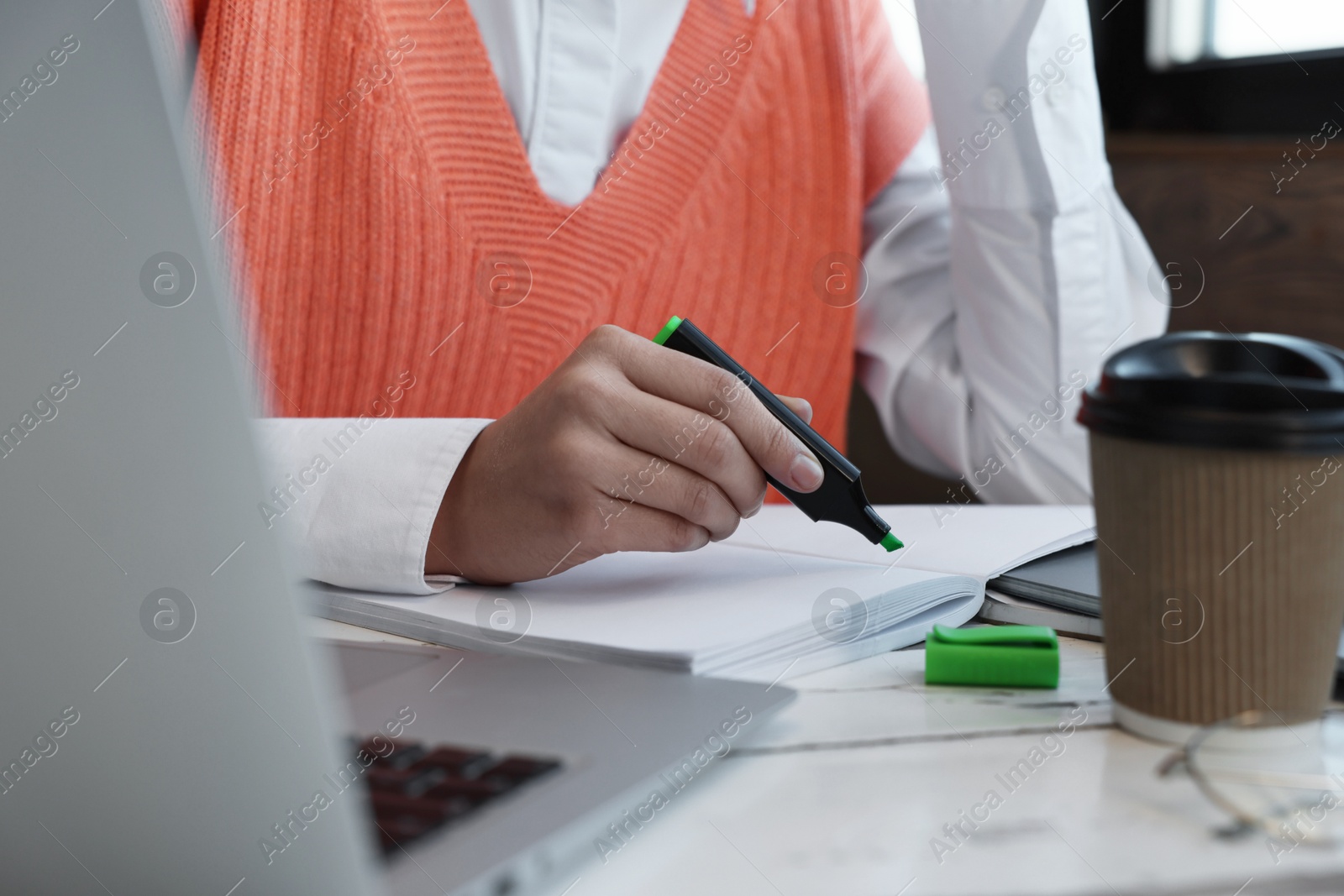 Photo of Young female student studying at table in cafe, closeup