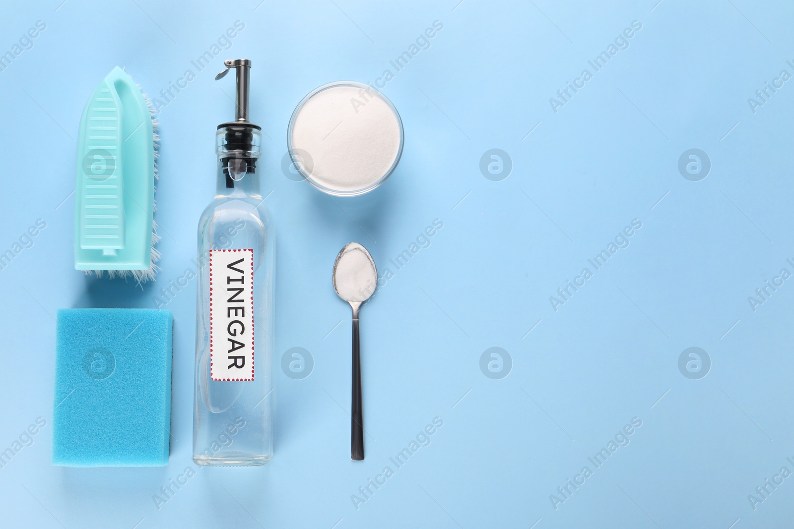 Photo of Eco friendly natural cleaners. Flat lay composition with bottle of vinegar on light blue background, space for text