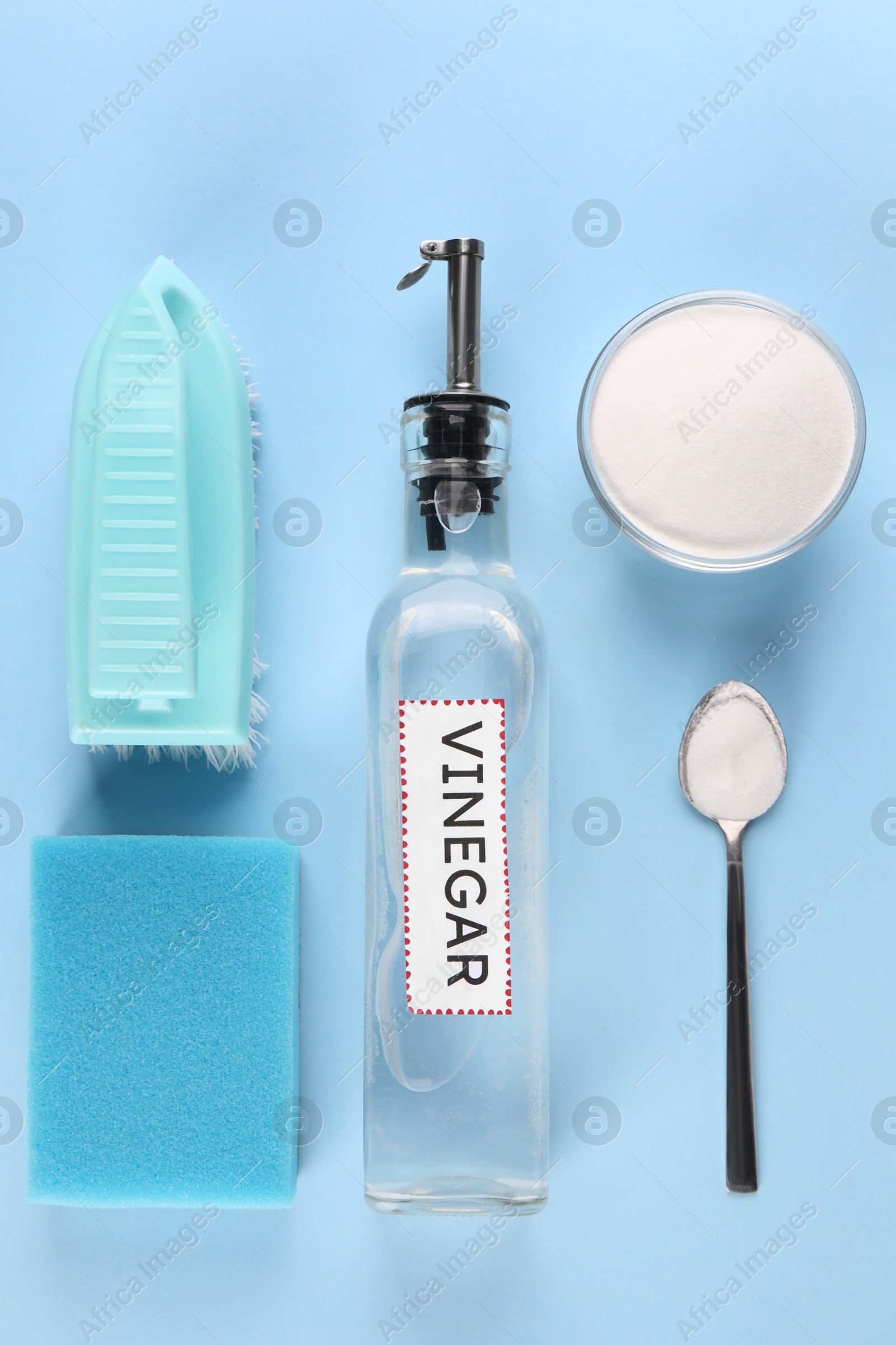 Photo of Eco friendly natural cleaners. Flat lay composition with bottle of vinegar on light blue background