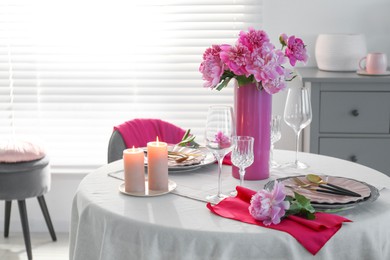 Photo of Beautiful table setting with pink peonies and burning candles