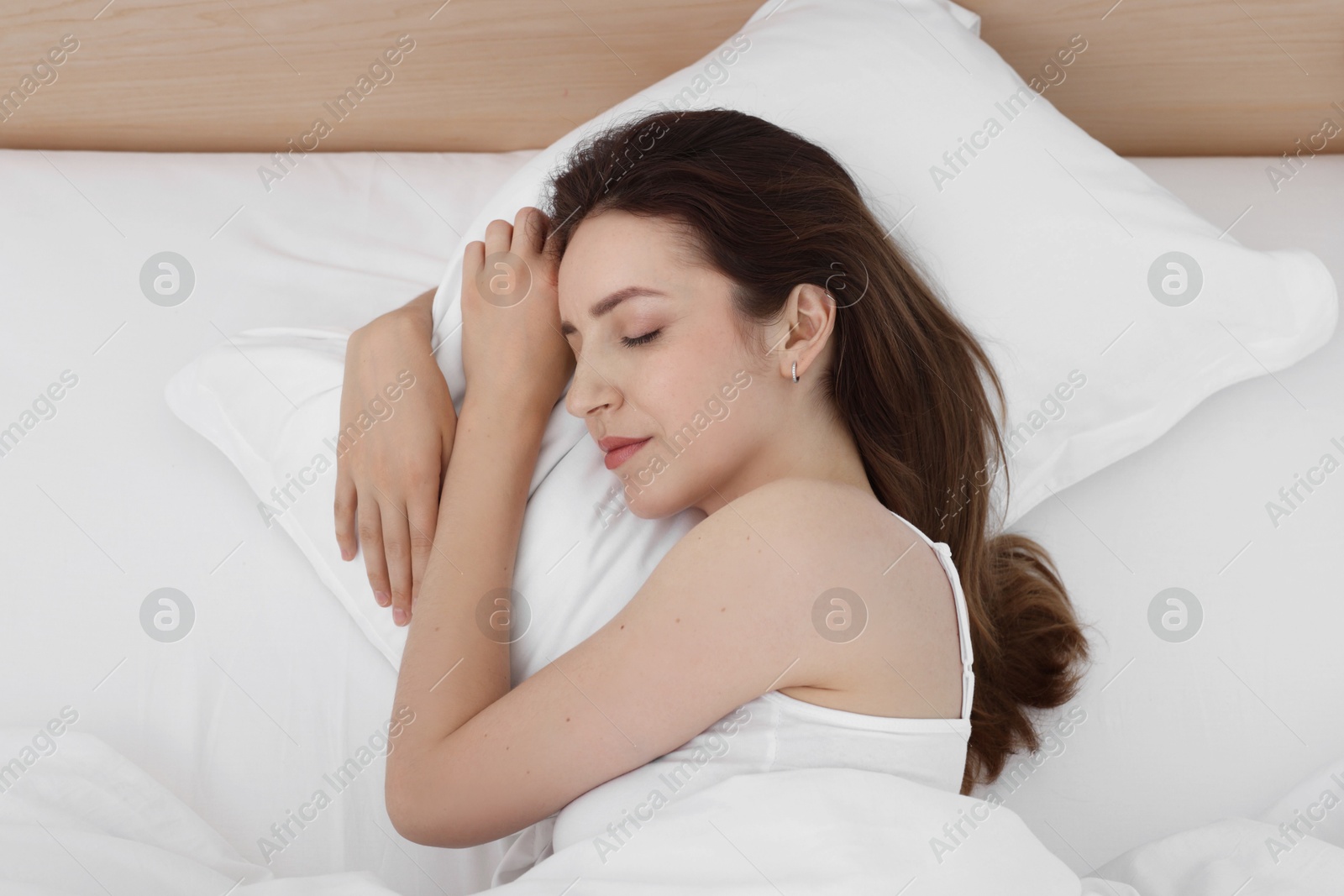 Photo of Bedtime. Woman sleeping in bed at home, above view