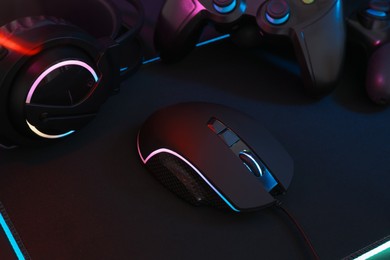 Photo of Computer mouse, headset and game controllers on table, closeup