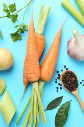 Photo of Fresh ripe carrots, vegetables, spices and spoon on light blue background, flat lay