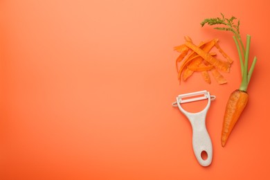 Fresh carrot, vegetable peeler and peels on orange background, flat lay. Space for text