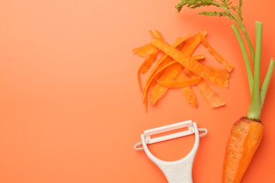 Photo of Fresh carrot, vegetable peeler and peels on orange background, flat lay. Space for text