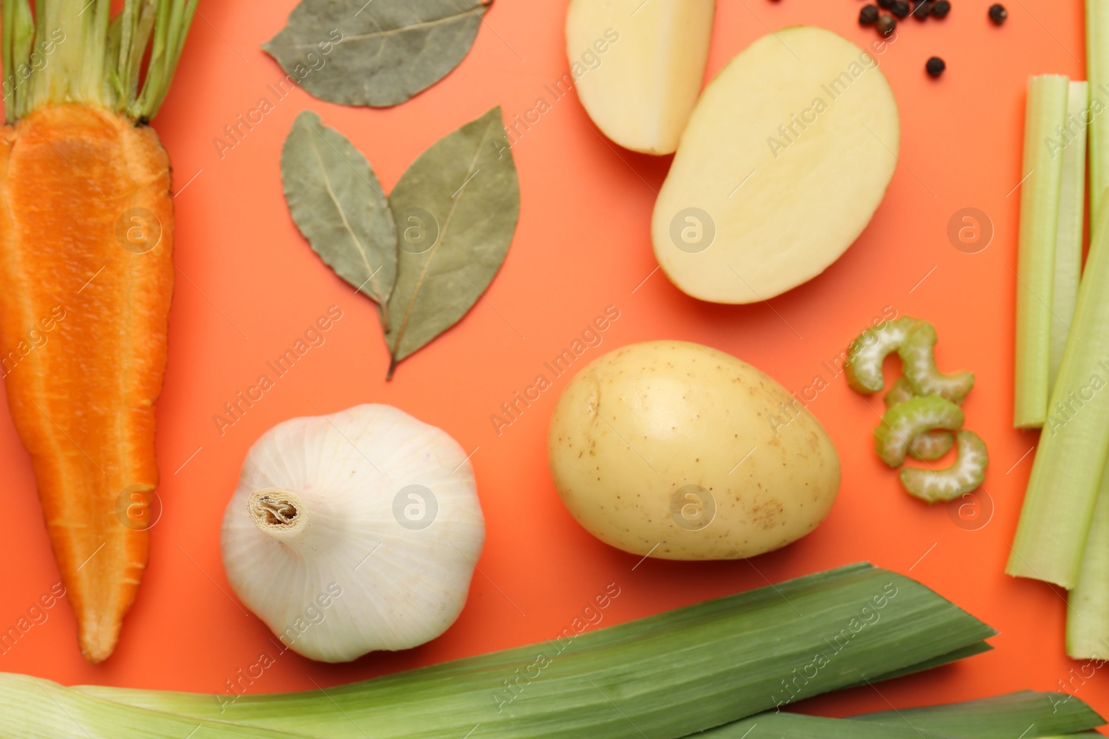 Photo of Fresh ripe carrot, vegetables and spices on orange background, flat lay