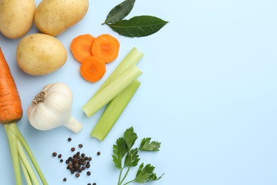 Photo of Fresh ripe carrots, vegetables and spices on light blue background, flat lay. Space for text