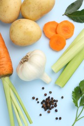 Photo of Fresh ripe carrots, vegetables and spices on light blue background, flat lay