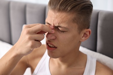 Photo of Young man suffering from sinusitis at home