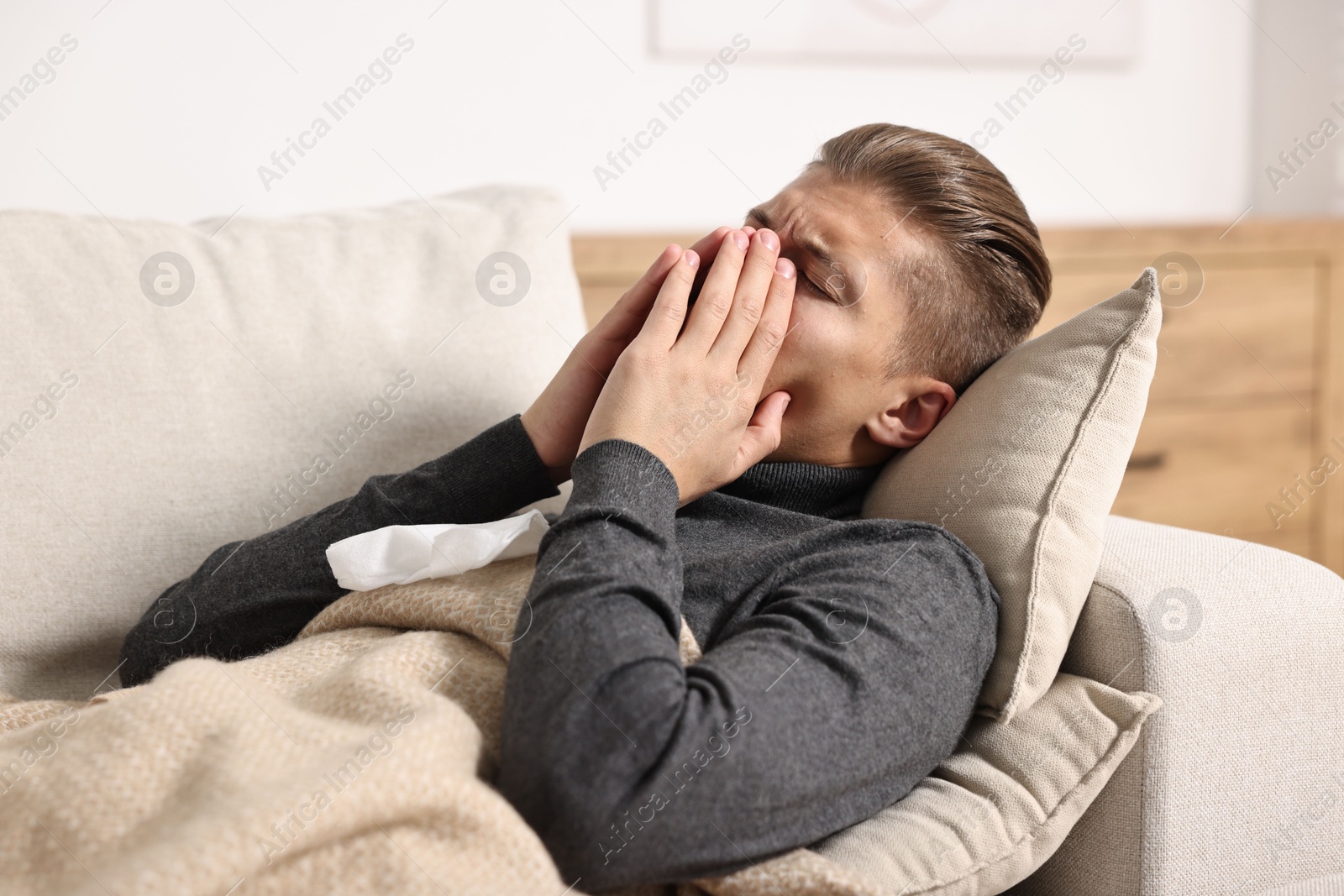 Photo of Young man suffering from sinusitis and lying in bed at home