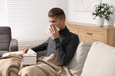 Photo of Young man with tissue suffering from sinusitis at home