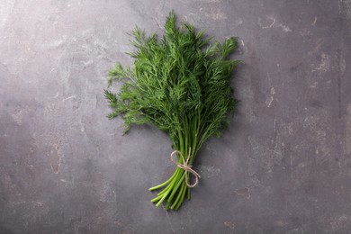 Bunch of fresh dill on grey textured table, top view