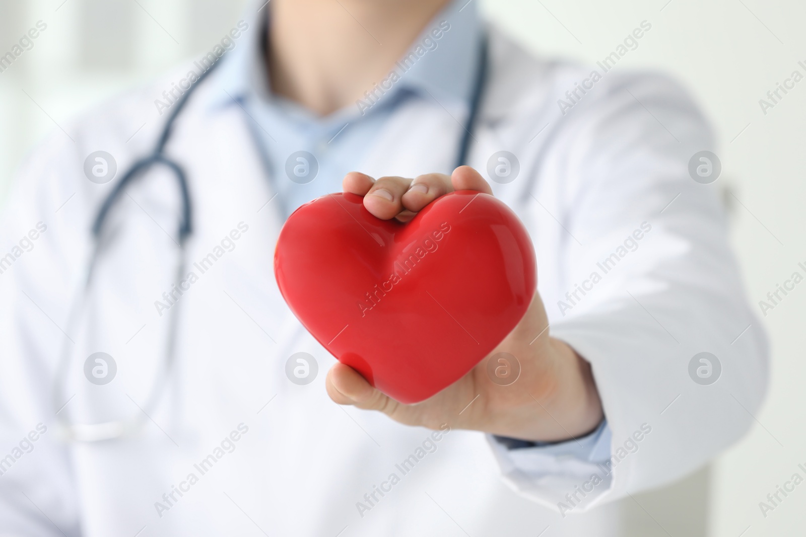 Photo of Doctor with red heart indoors, selective focus