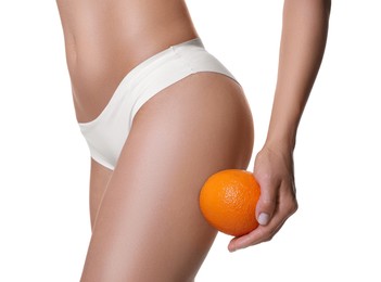 Photo of Woman in underwear with orange on white background, closeup. Cellulite problem