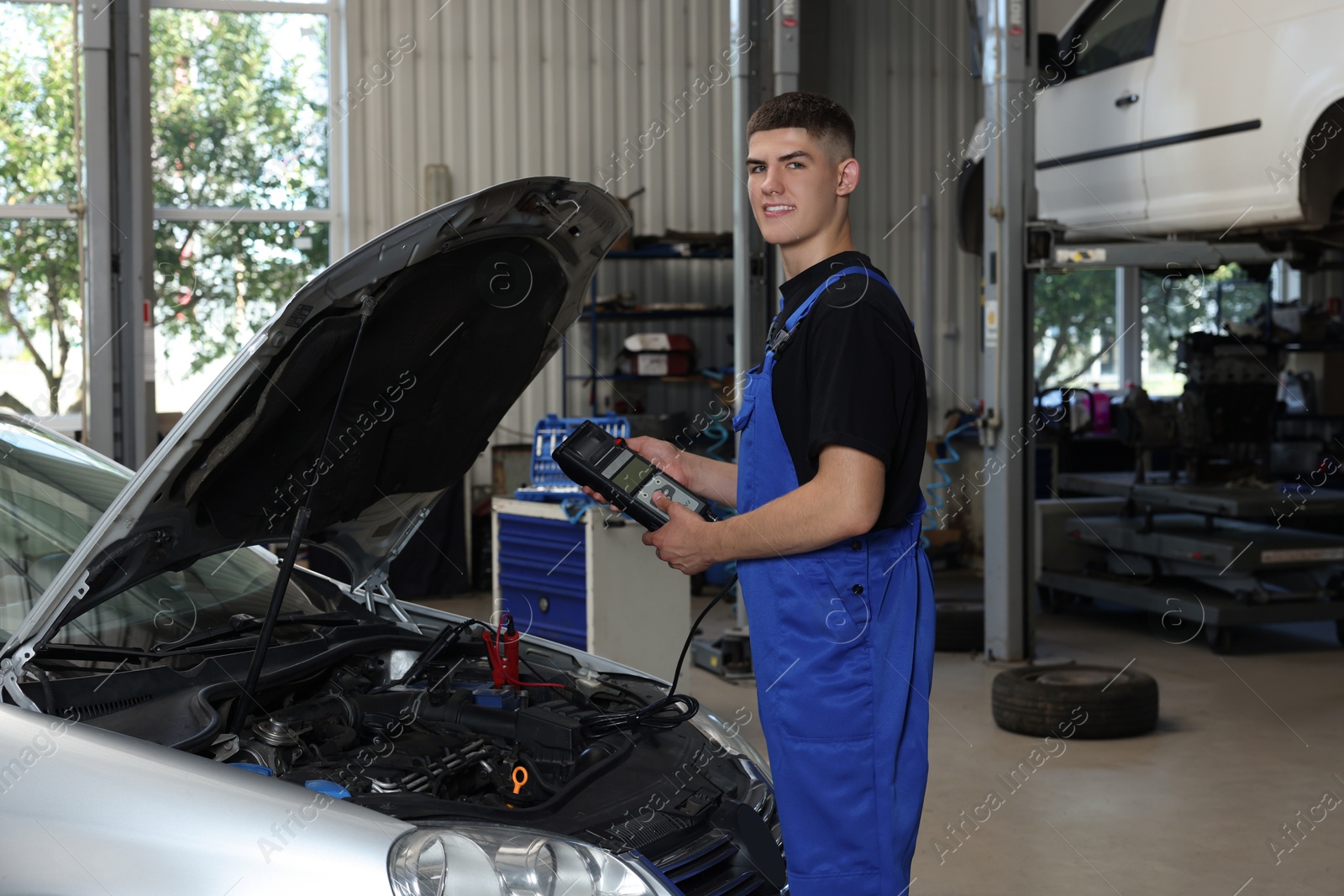 Photo of Young auto mechanic fixing car at automobile repair shop