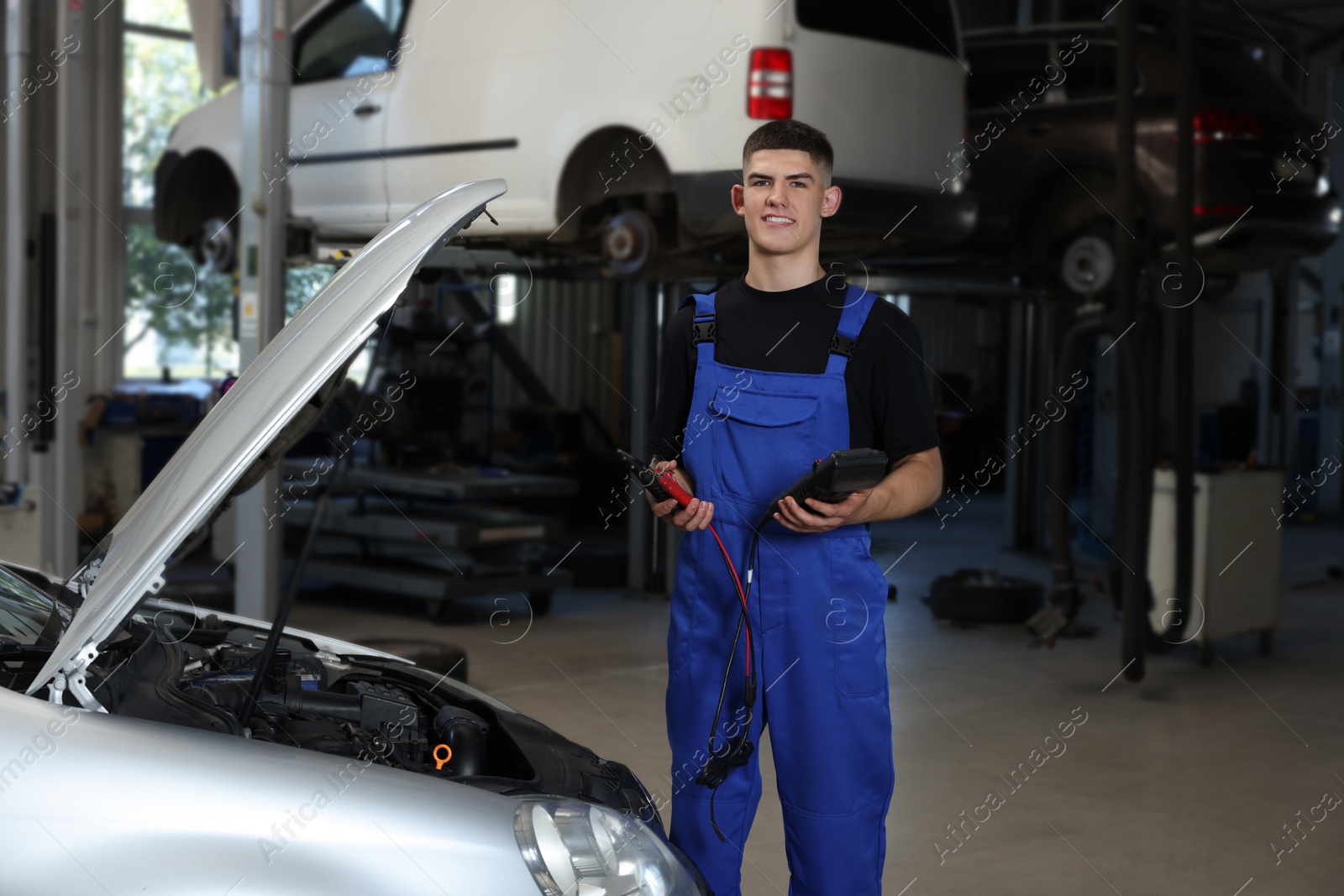 Photo of Young auto mechanic fixing car at automobile repair shop