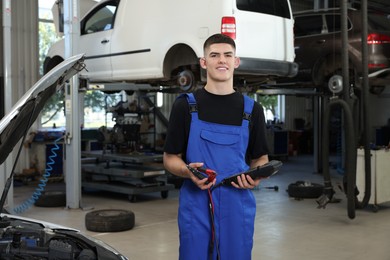 Photo of Young auto mechanic fixing car at automobile repair shop