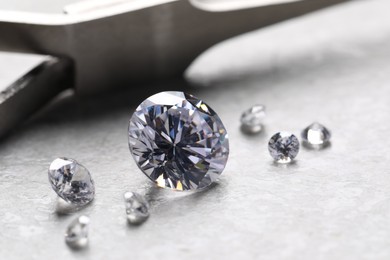 Photo of Many beautiful shiny diamonds on light background, closeup