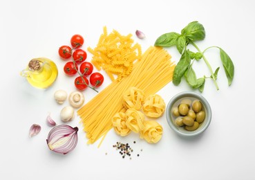 Different types of pasta, spices and products on white background, top view